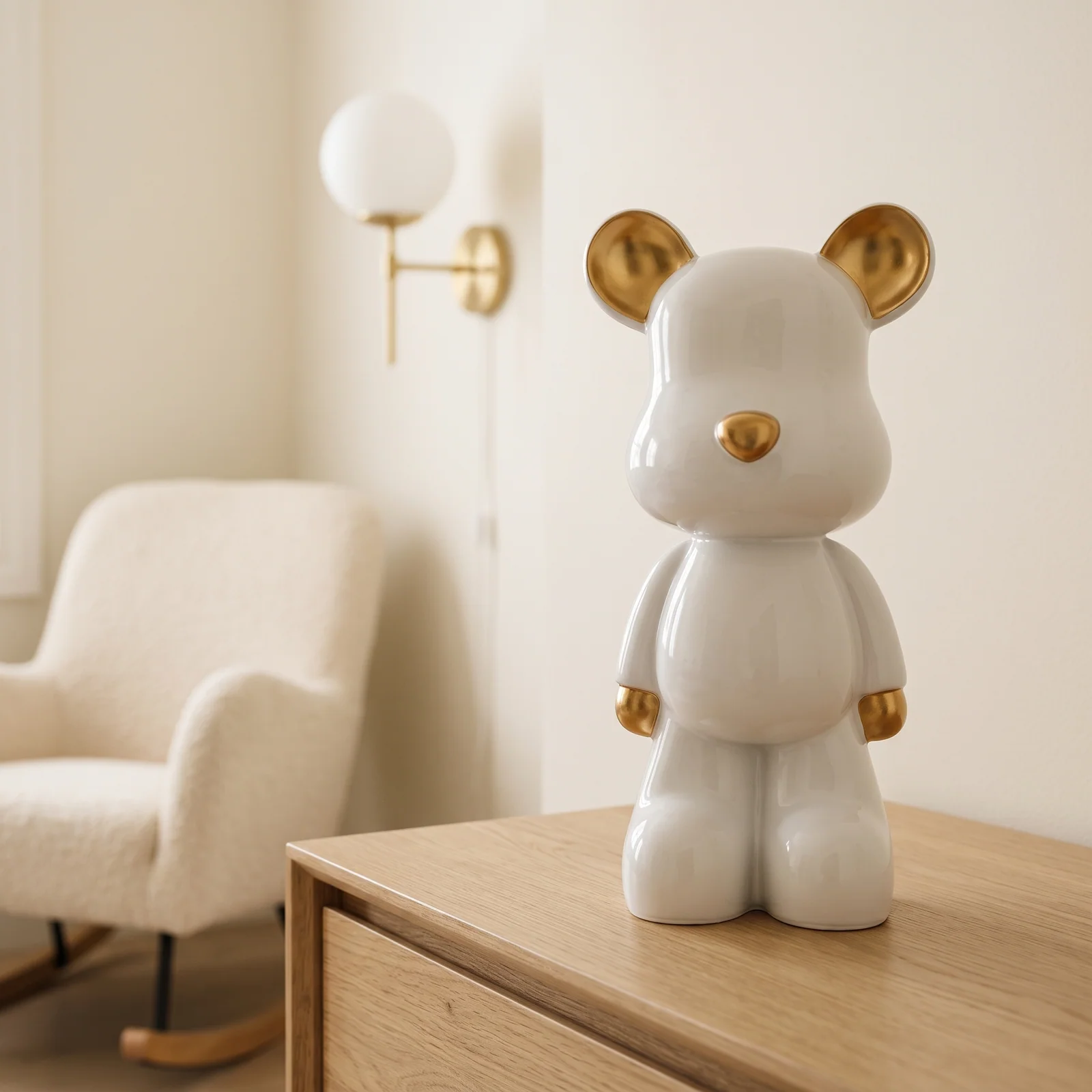 Wit-gouden design teddybeer van 48 cm op een lichte eiken commode in een serene kinderkamer met crème bouclé en een messing wandlampje — Fourdomus decoratie voor een kinderkamer.